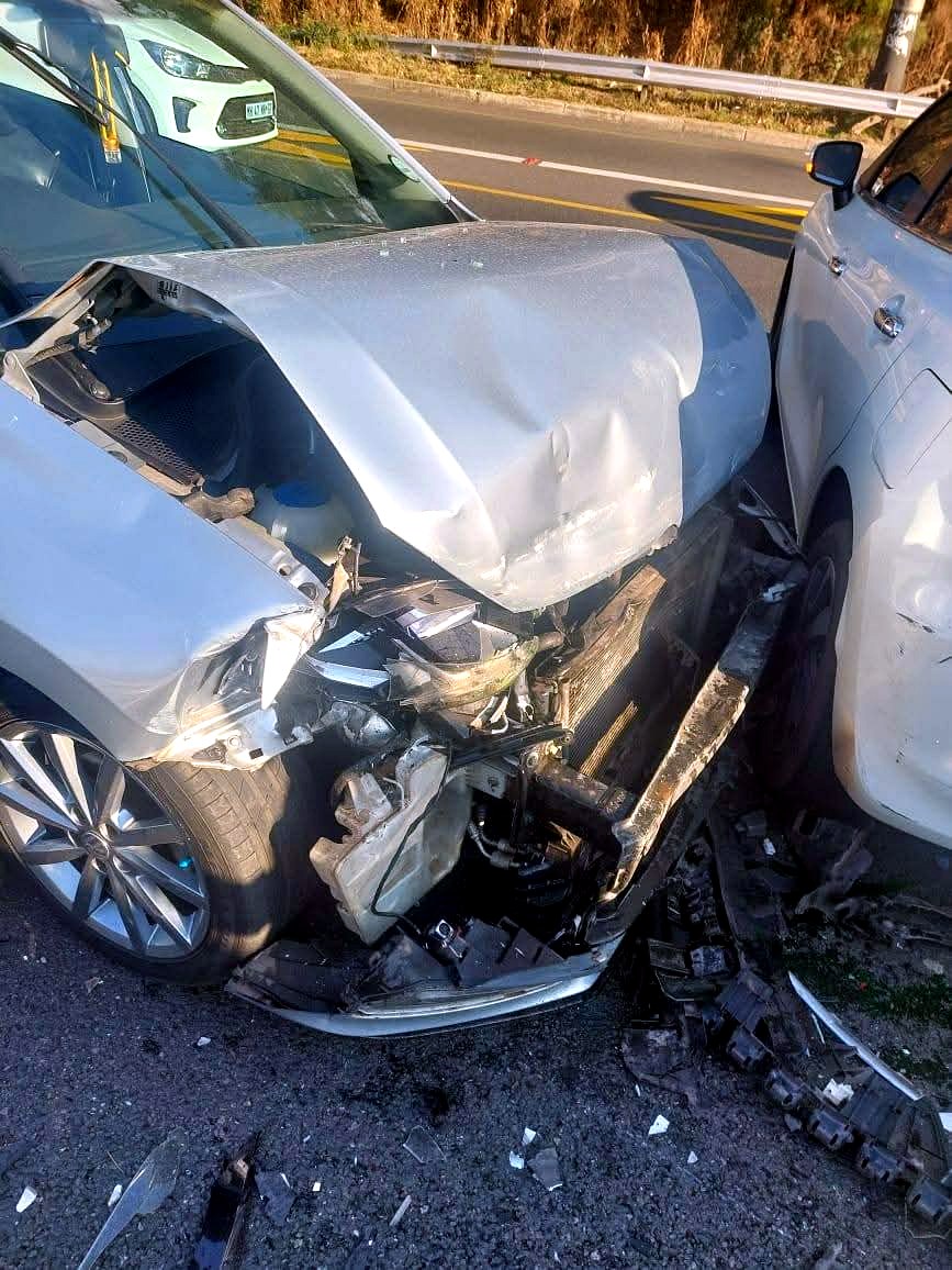 Front-end collision damage on a silver sedan before repair